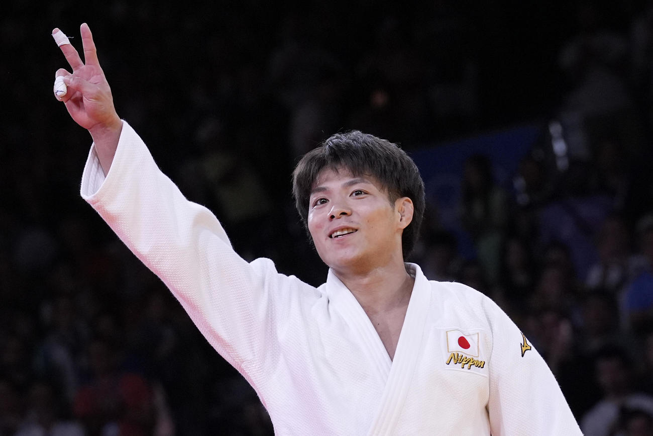 男子66キロ級決勝　五輪連覇を達成した阿部一二三は笑顔でVサイン（AP）