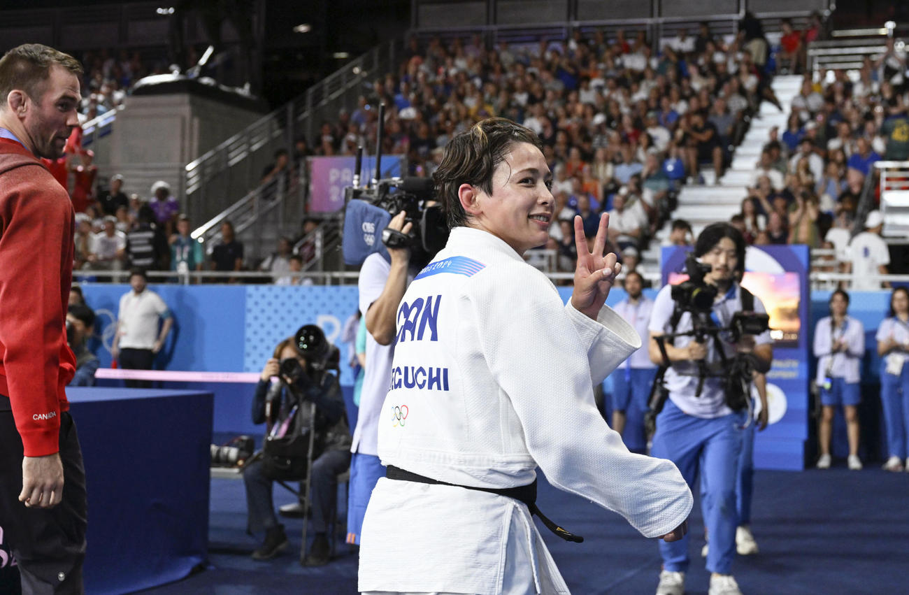 女子57キロ級で金メダルを獲得し、ポーズをとるカナダの出口クリスタ（共同）