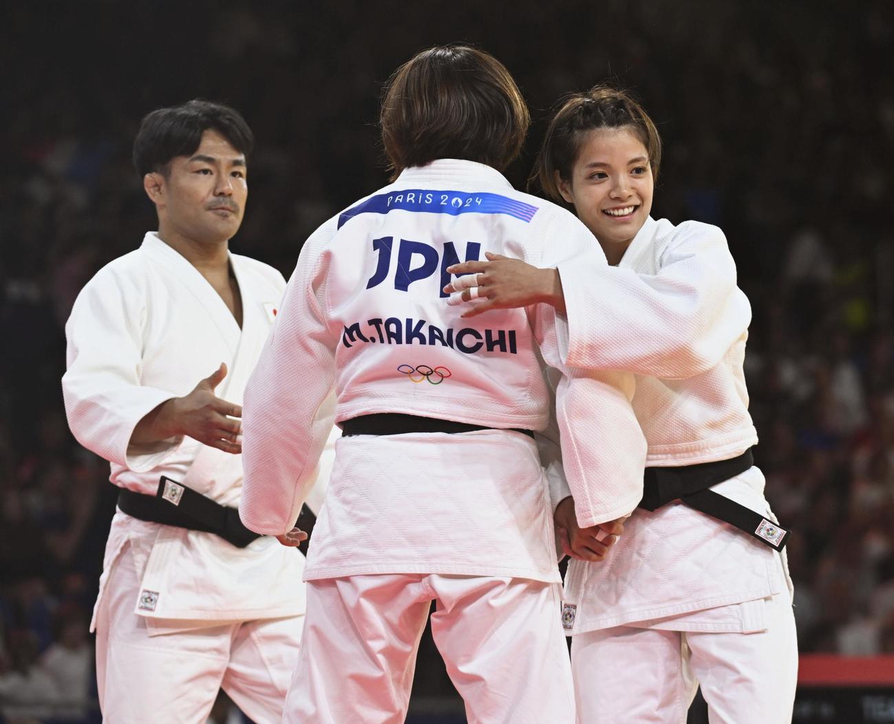 混合団体2回戦でスペインに勝利し、高市未来を笑顔で迎える阿部詩。左は橋本壮市＝パリ（共同）