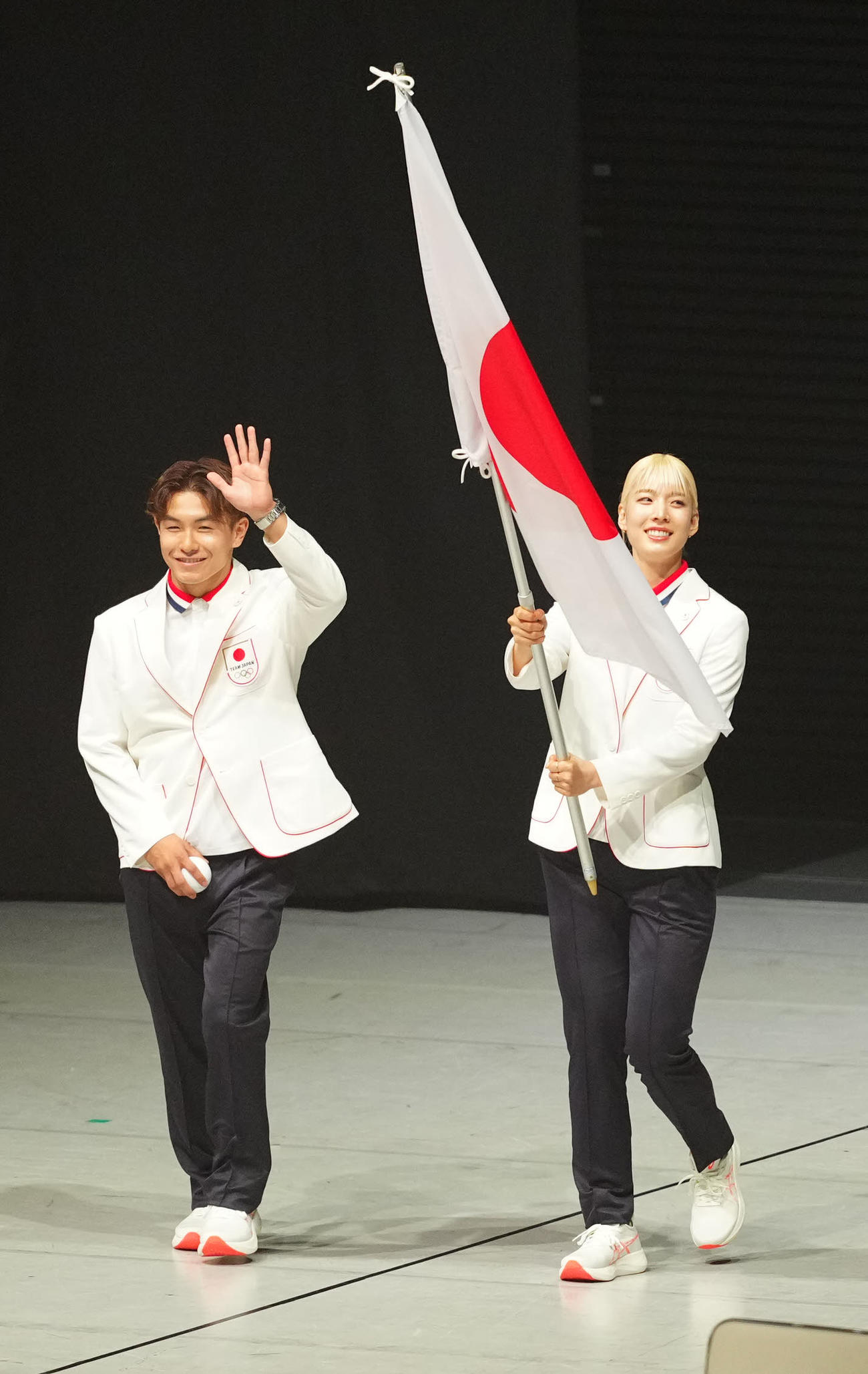 パリ五輪日本選手団「TEAM JAPAN」の壮行会で入場する旗手を務めるフェンシングの江村（右）とブレイキンの半井（撮影・江口和貴）