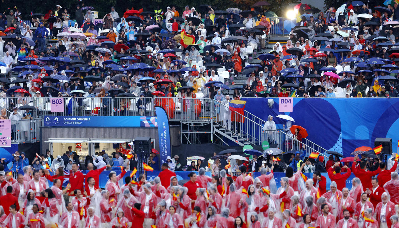 雨の中、パリ五輪の開会式を見る大勢の人たち（共同）