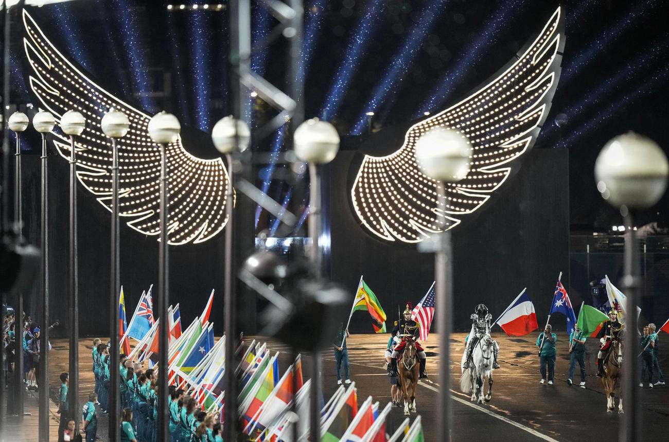 パリ五輪の開会式に登場した馬と各国の国旗（共同）