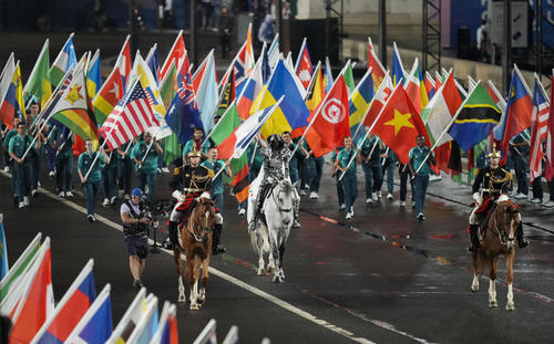 パリ五輪の開会式に登場した馬と国旗（共同）