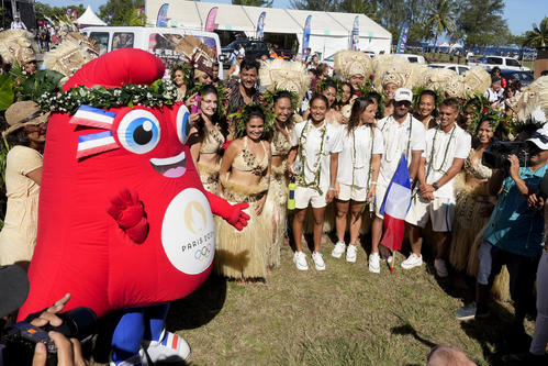 パリ五輪、サーフィン会場のタヒチで行われたオープニングセレモニー。マスコットと一緒に記念撮影する選手ら（AP）