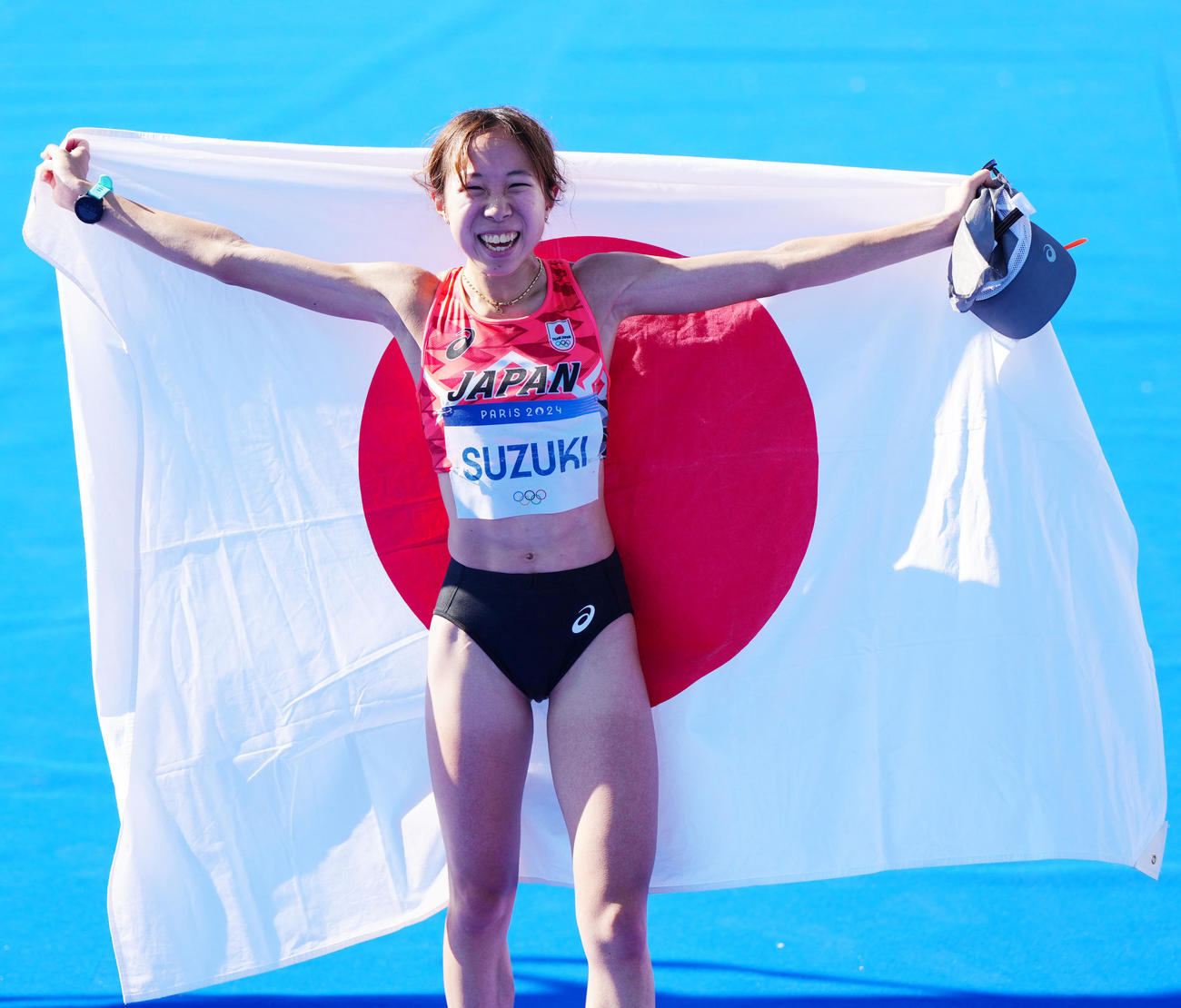 女子マラソンで6位入賞し日の丸を掲げる鈴木（撮影・江口和貴）
