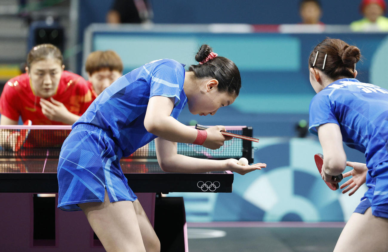 女子団体決勝　中国戦の第1試合でサーブする張本美和。右は早田ひな（共同）