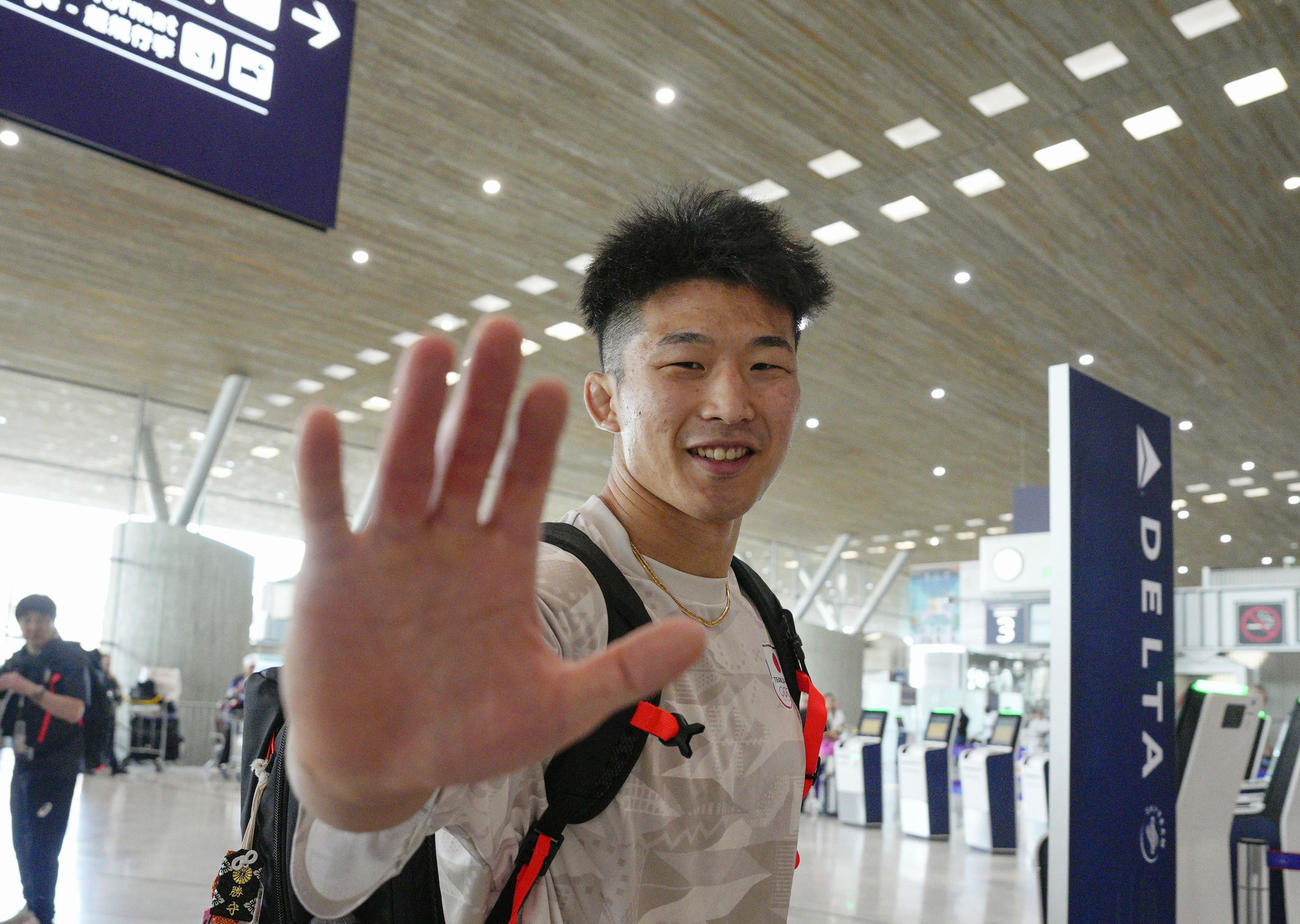 パリ五輪閉会式に出演した米俳優トム・クルーズさんと握手した手を見せる、レスリング男子の日下尚（共同）