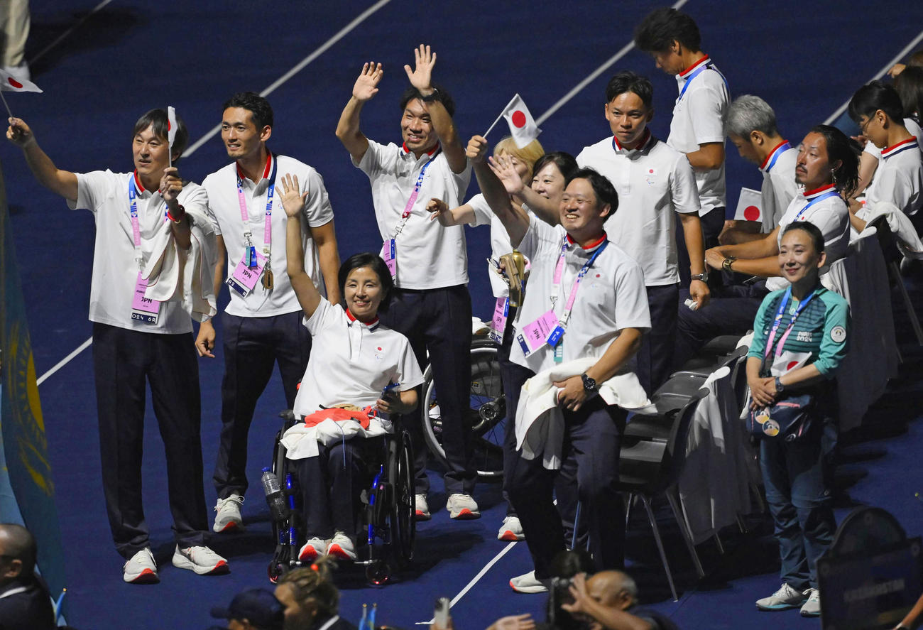 パリ・パラリンピックの開会式で、客席に手を振る田口亜希団長（左から3人目）ら日本選手団（共同）