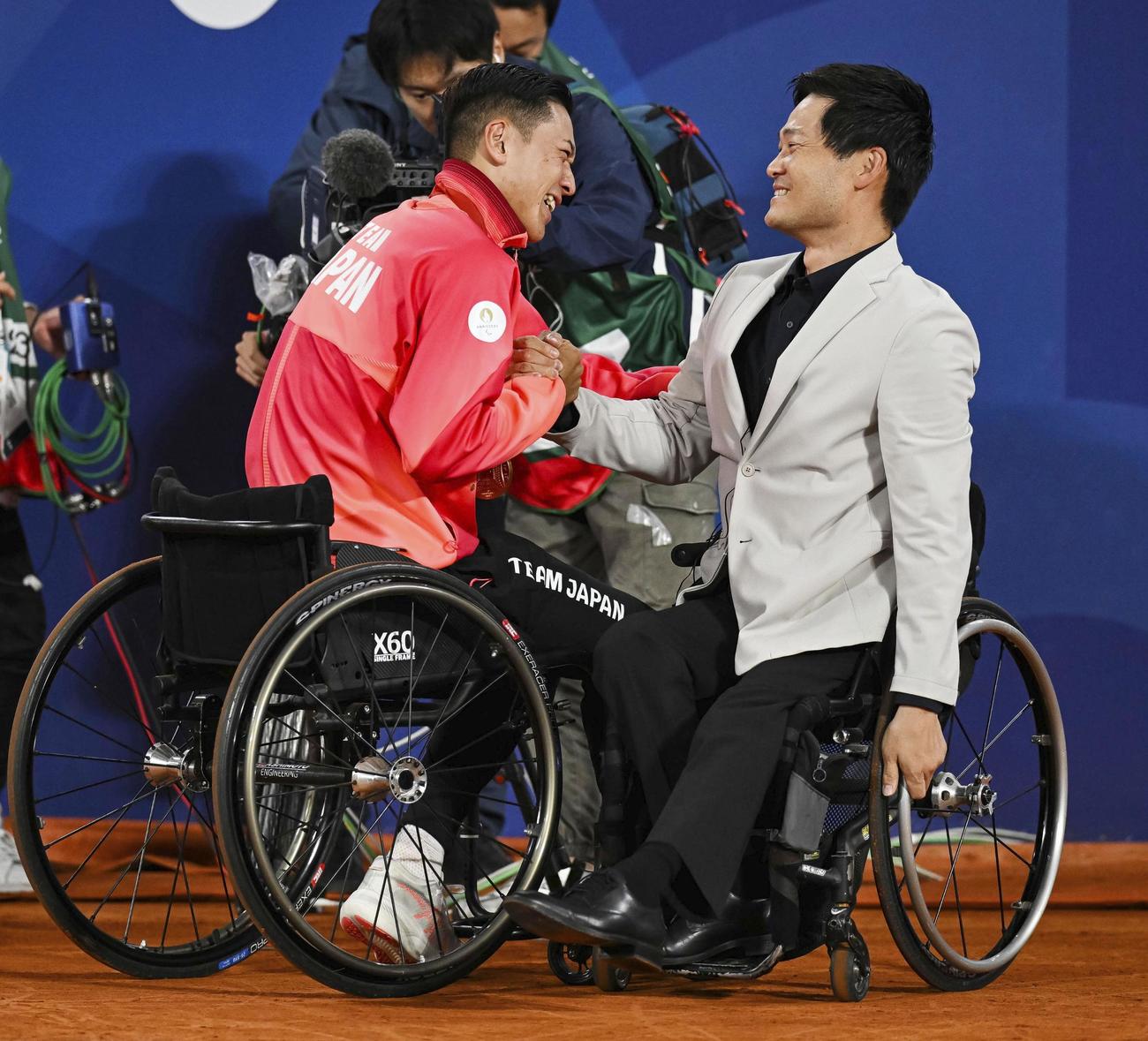 車いすテニス男子シングルスで優勝した小田凱人（左）と握手する国枝慎吾さん（ゲッティ＝共同）