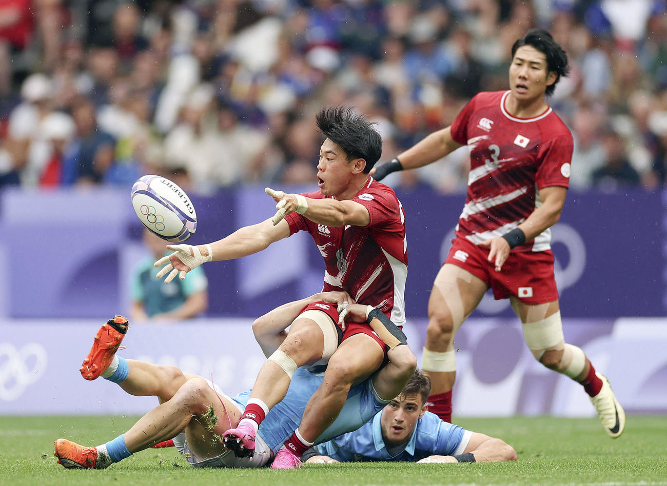 ウルグアイ戦でタックルされる野口（手前）（ゲッティ＝共同）