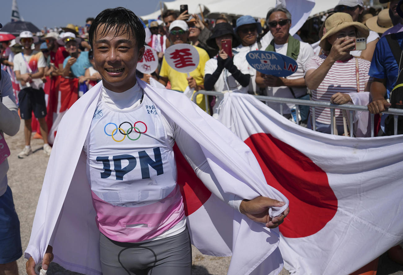 混合470級で銀メダルを獲得し、日の丸を身にまとう岡田奎樹（AP)