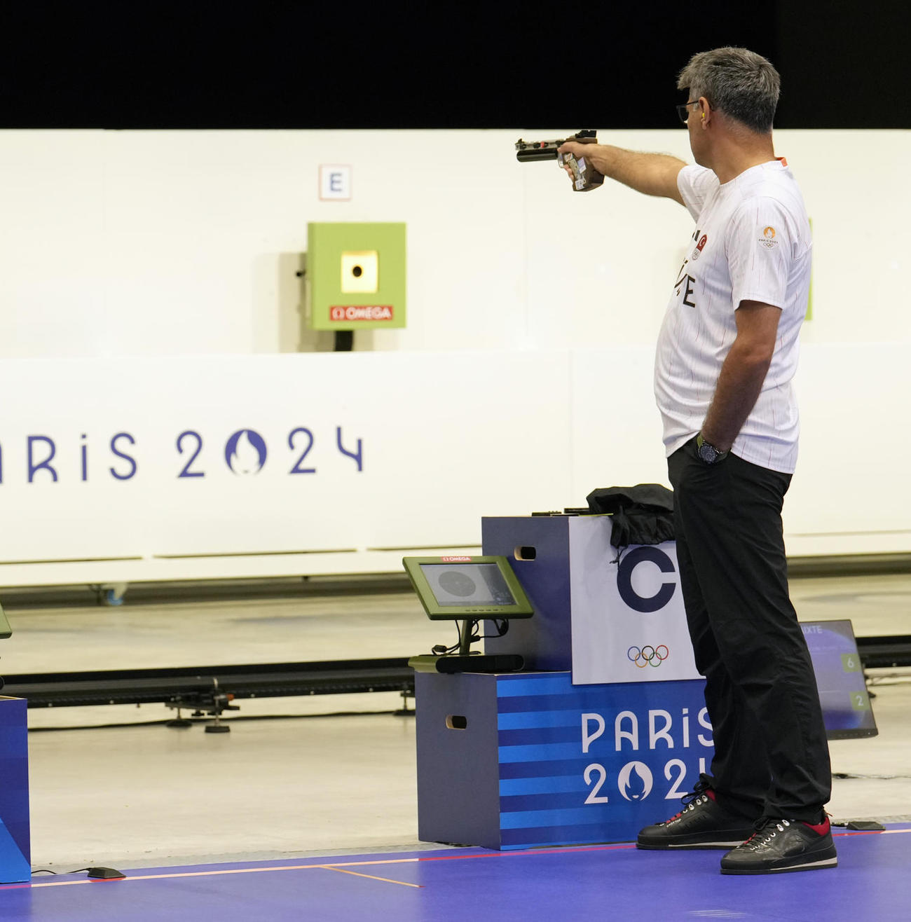 パリ五輪の射撃混合エアピストルにTシャツ無装備で出場し、左手をポケットに入れながら銃を撃つトルコのユスフ・ディケチュ（AP）