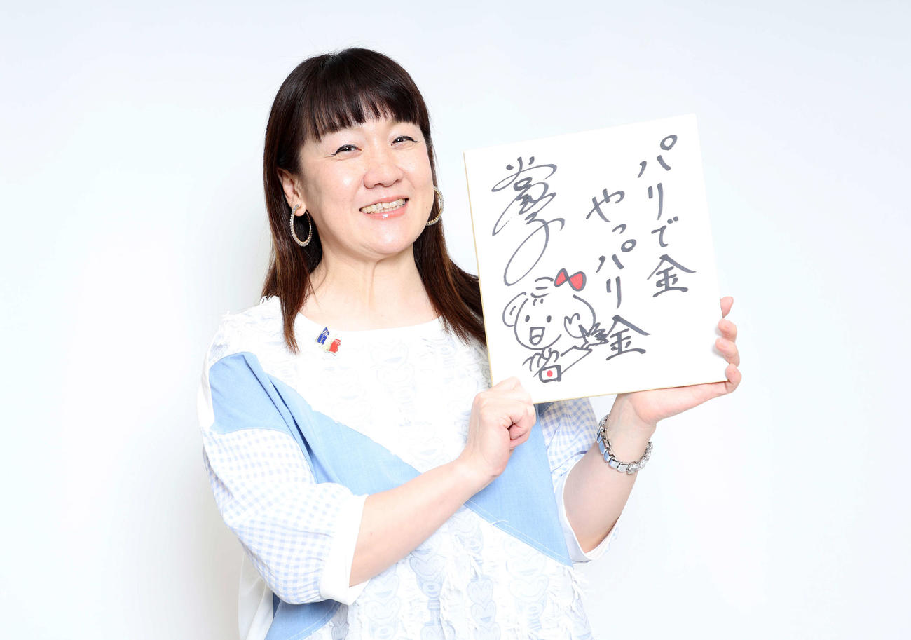 「パリで金　やっぱり金」の色紙を手に笑顔を見せる谷亮子さん（撮影・鈴木正人）