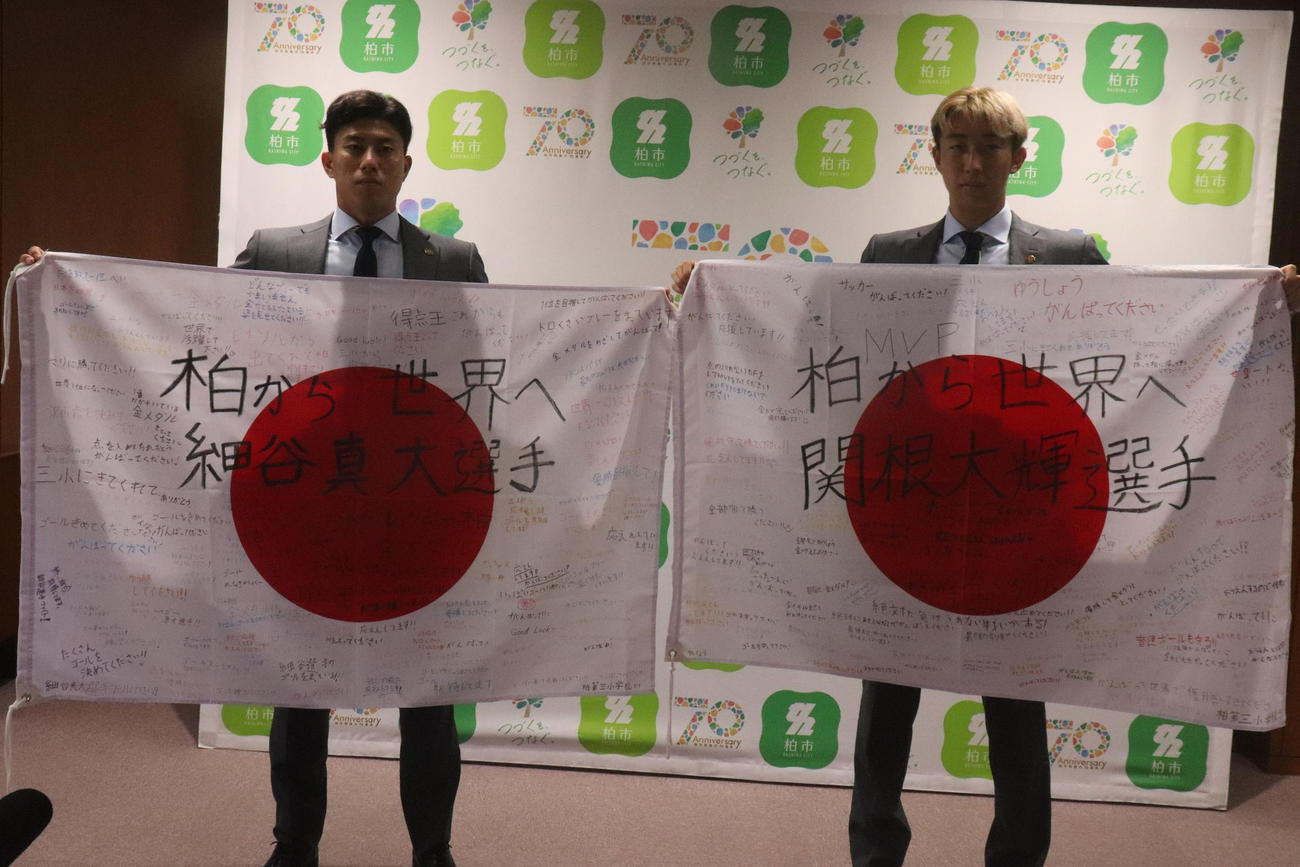 パリ五輪代表に選出され、柏市役所を表敬訪問し、柏第三小学校の児童からの寄せ書きを受け取った柏FW細谷（左）とDF関根