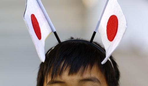 日本国旗のカチューシャをつけたサポーター（ロイター）