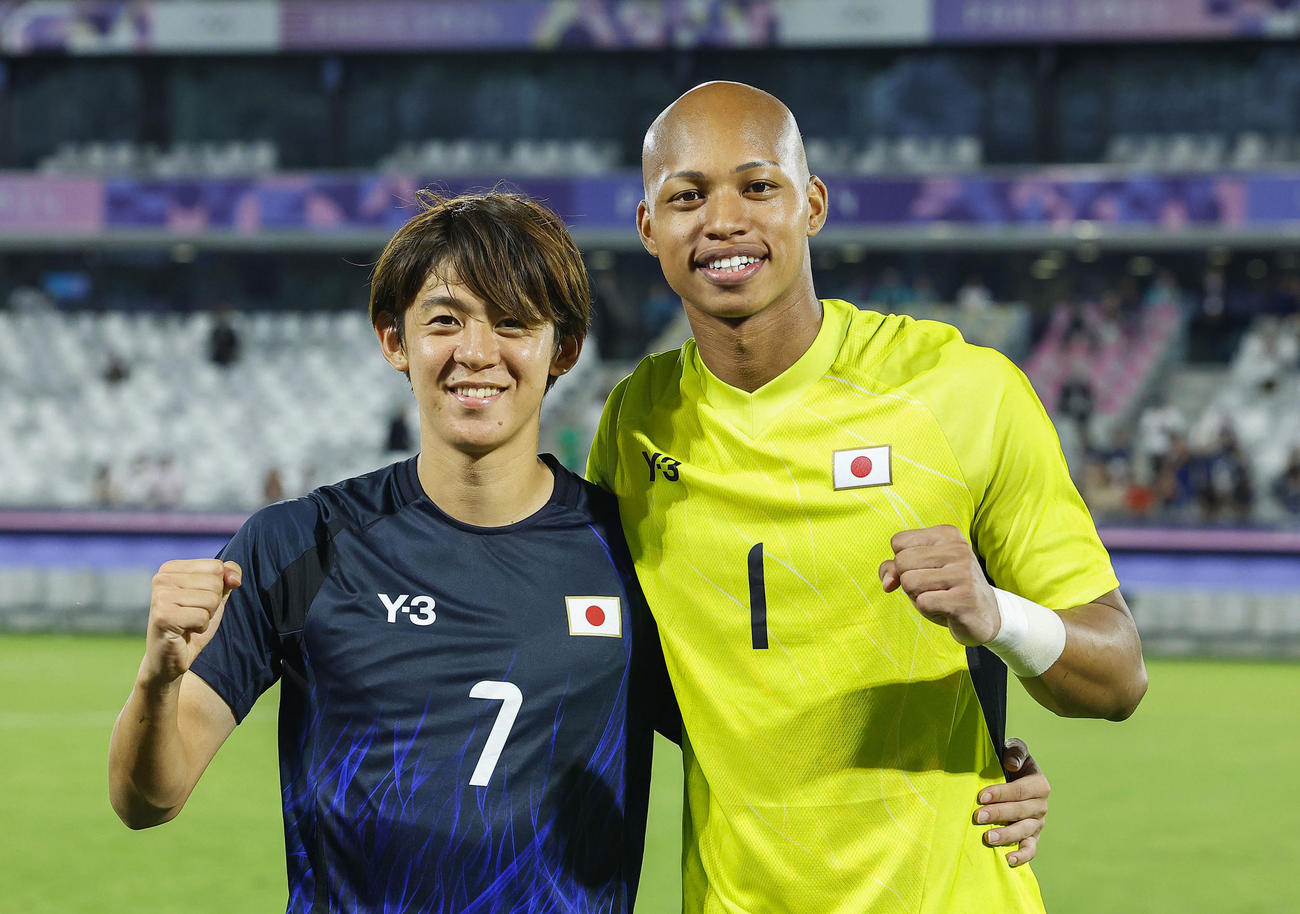 マリに競り勝ち、準々決勝進出を決め、写真に納まる山本（左）とGK小久保（共同）