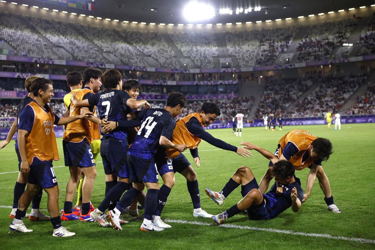 先制点を挙げた山本を祝福する日本の選手たち（ロイター）