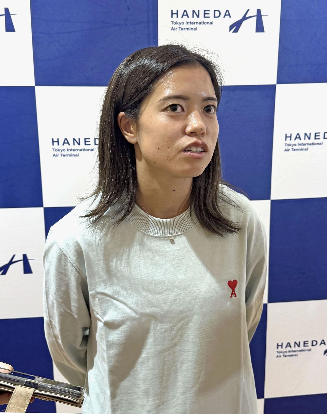 羽田空港で取材に応じるサッカー女子日本代表の長谷川唯（共同）