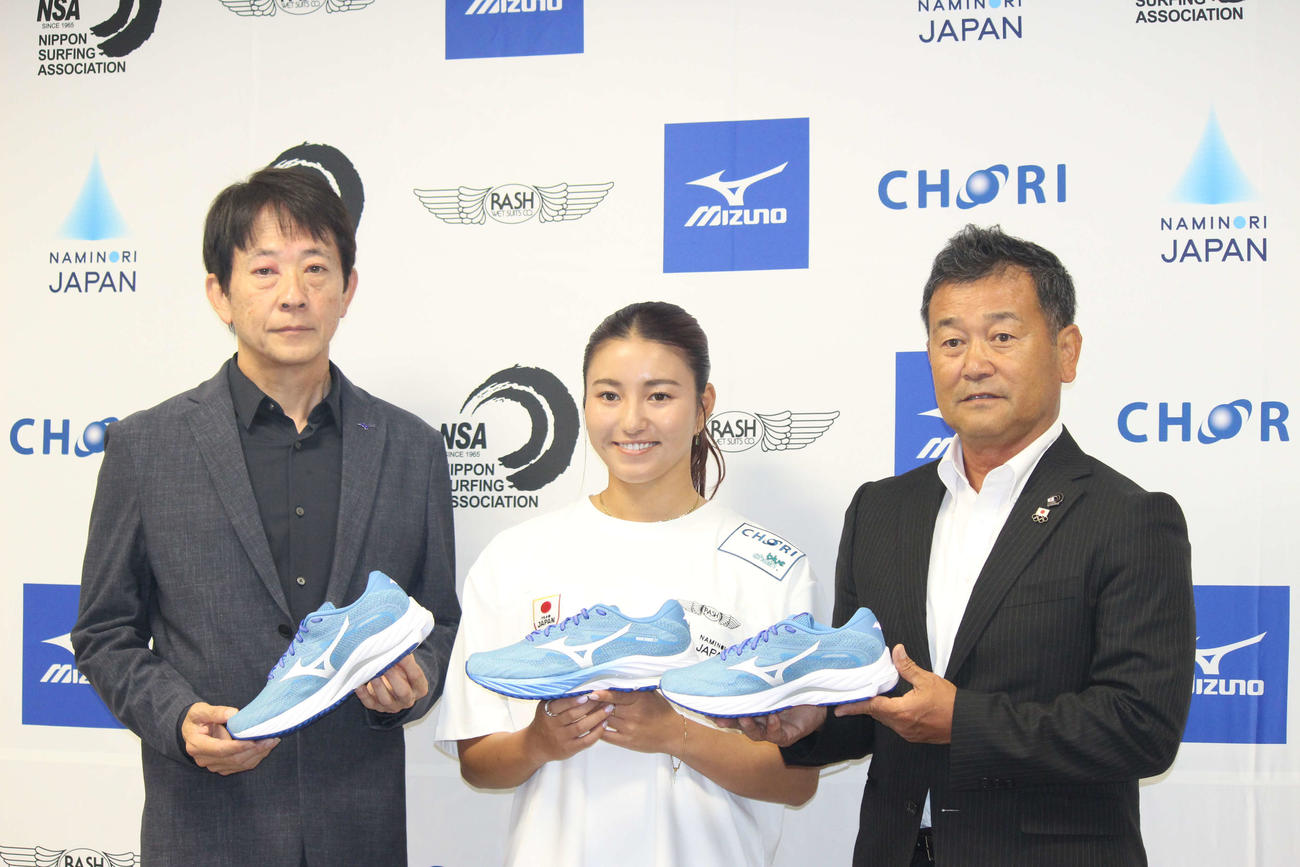 シューズを手に写真に納まるサーフィン日本代表の松田詩野（中央）（撮影・勝部晃多）