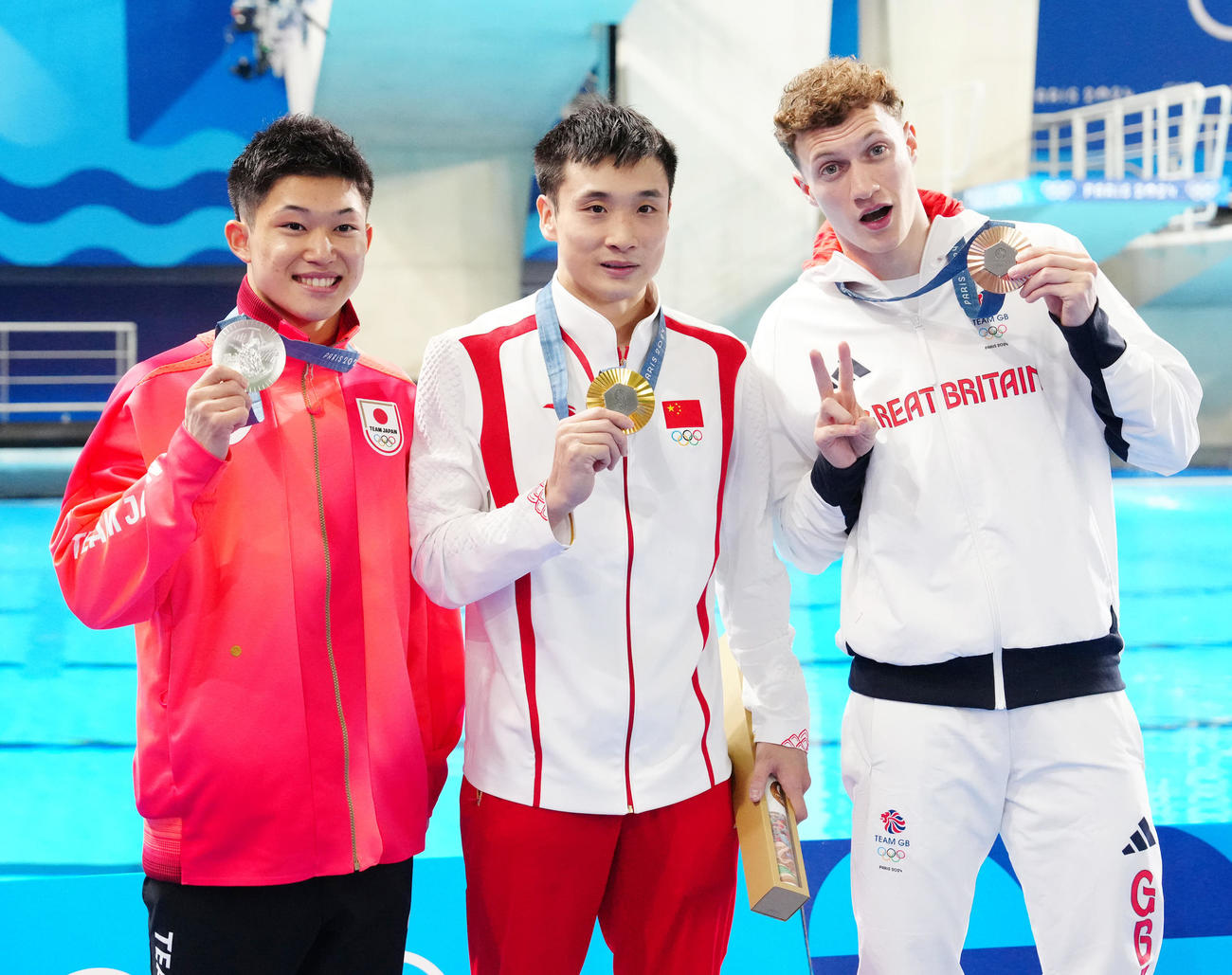 男子高飛び込みでメダルを手に写真に納まる選手たち。左から銀メダルの玉井、金メダルの中国の曹縁、銅メダルの英国のウィリアムズ（撮影・江口和貴）
