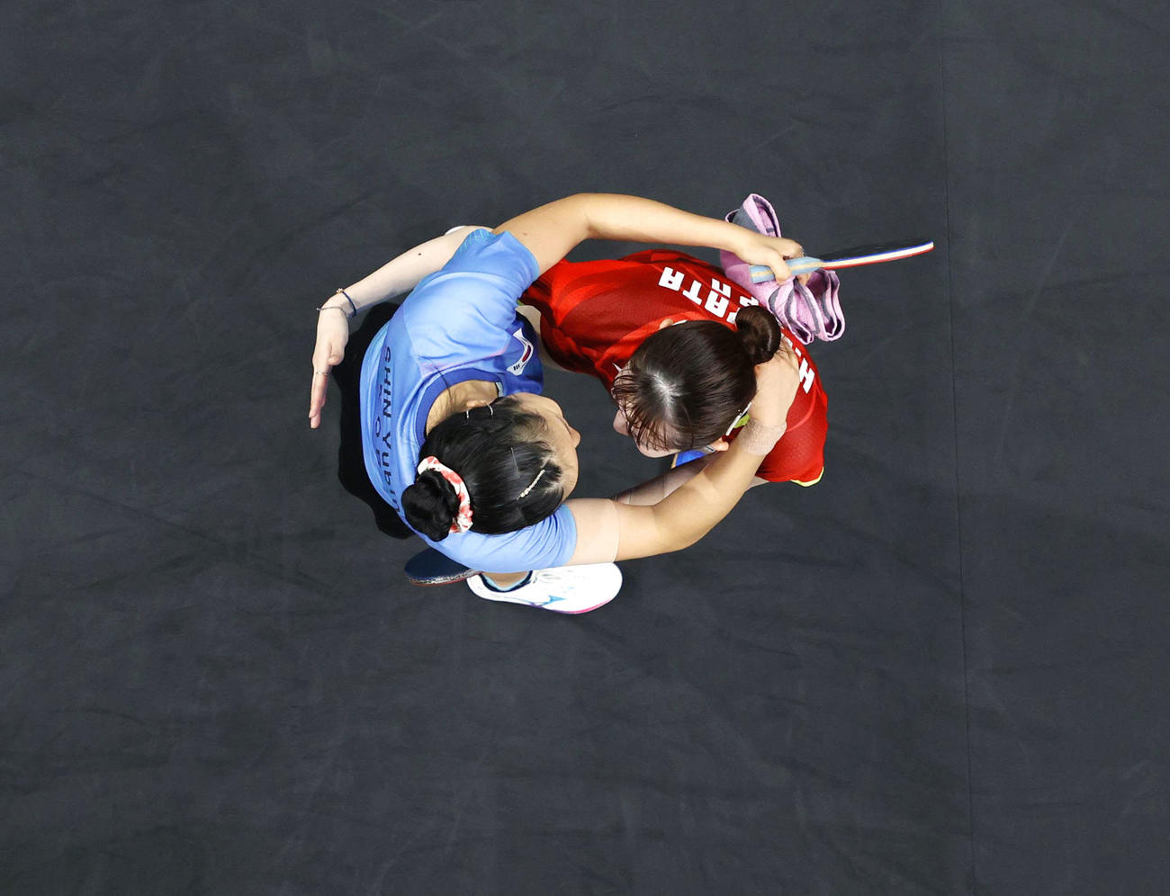 女子シングルスで銅メダルを獲得し、韓国選手（左）と抱き合う早田ひな＝パリ（共同）