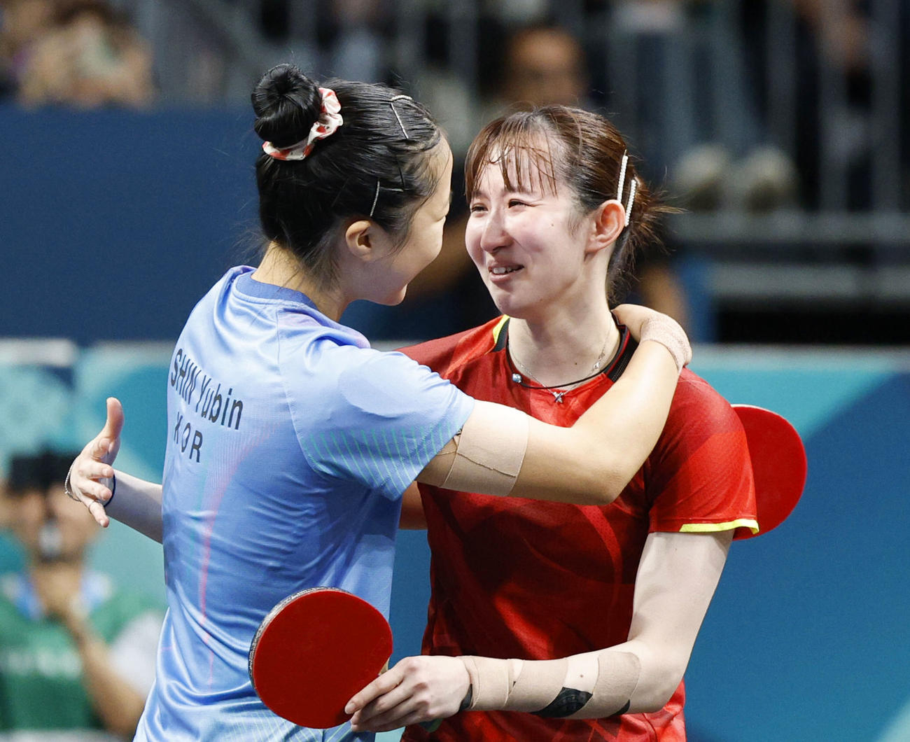 女子シングルスで銅メダル獲得を決め、韓国の申裕斌（左）と健闘をたたえ合う早田ひな＝パリ（共同）