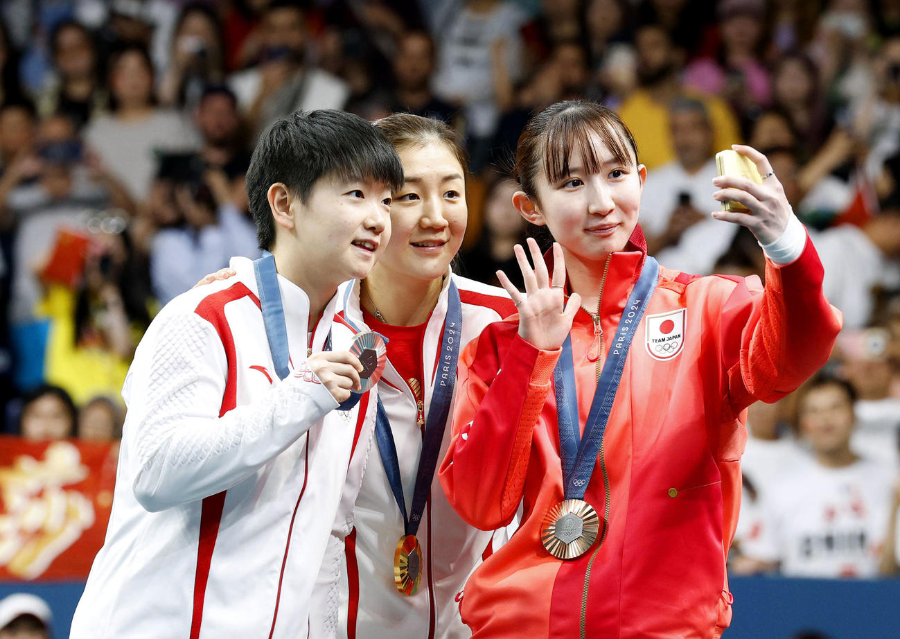 卓球女子シングルスで銅メダルを獲得し、表彰式で記念撮影する早田ひな（右）（共同）