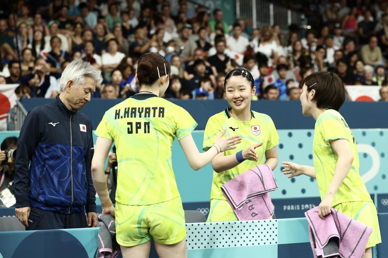 女子団体1回戦　ダブルスで勝利する早田（手前左）、平野（同右）を迎える張本（中央）と渡辺監督（撮影・河田真司）