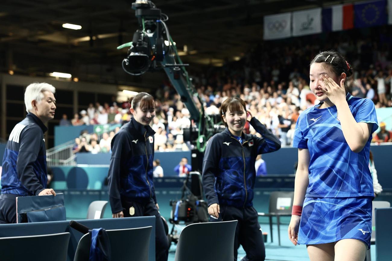女子団体準決勝　ドイツに勝利し決勝進出を決め、涙を流しながら引き揚げる準備をする張本（右）。左から渡辺監督、早田、平野（撮影・河田真司）
