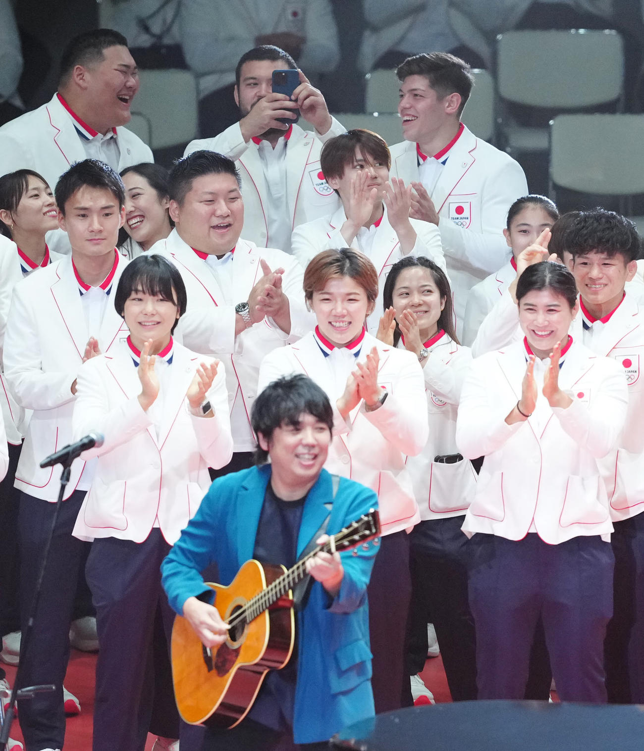 パリ五輪日本選手団「TEAM JAPAN」の壮行会でライブを行うスキマスイッチの近くに集まるレスリングの藤波（手前左）ら選手たち（撮影・江口和貴）
