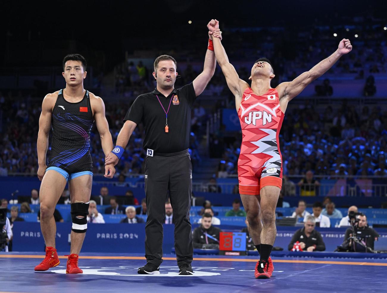 男子グレコローマン60 キロ 級決勝　中国選手（左）を破り、金メダルを獲得した文田健一郎（共同）