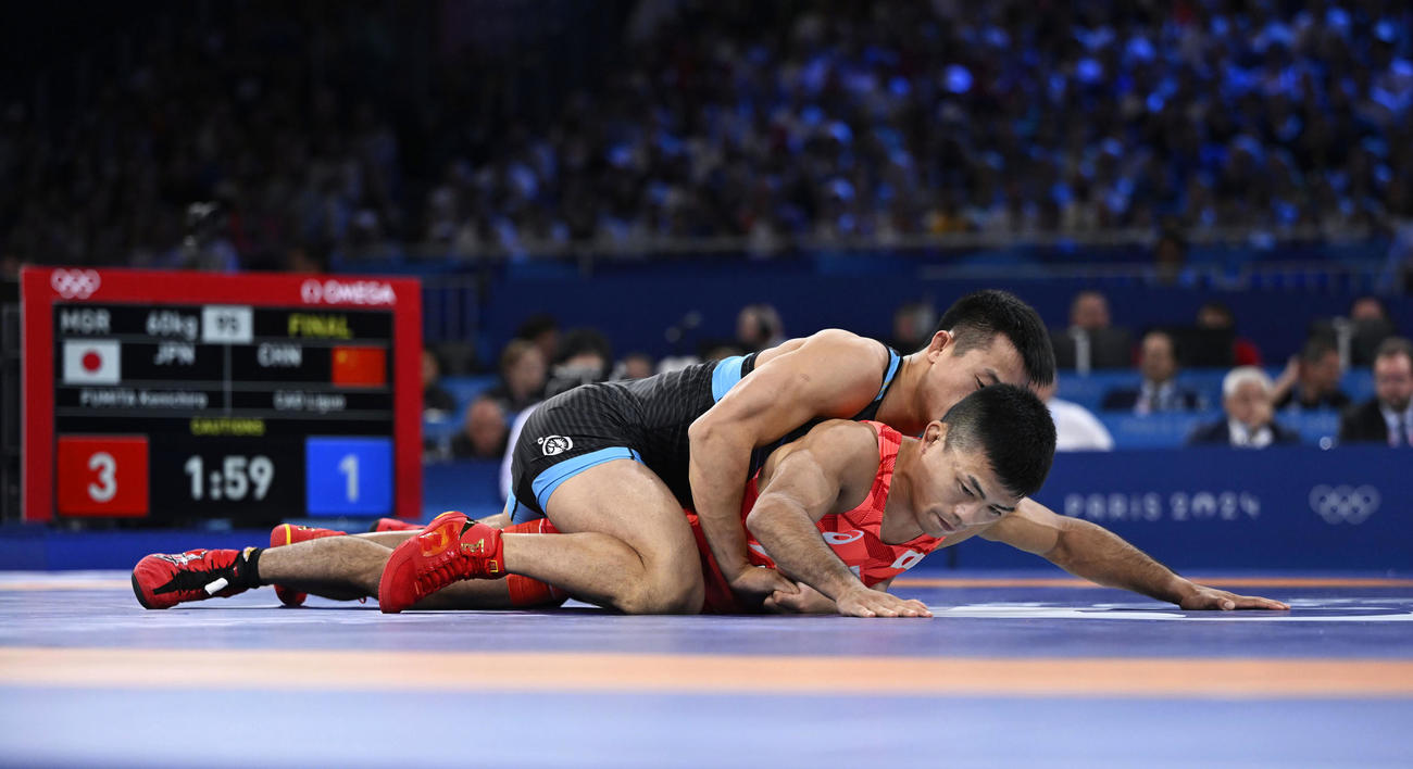 男子グレコローマン60 キロ 級決勝　中国選手（上）の攻めをこらえる文田健一郎（共同）