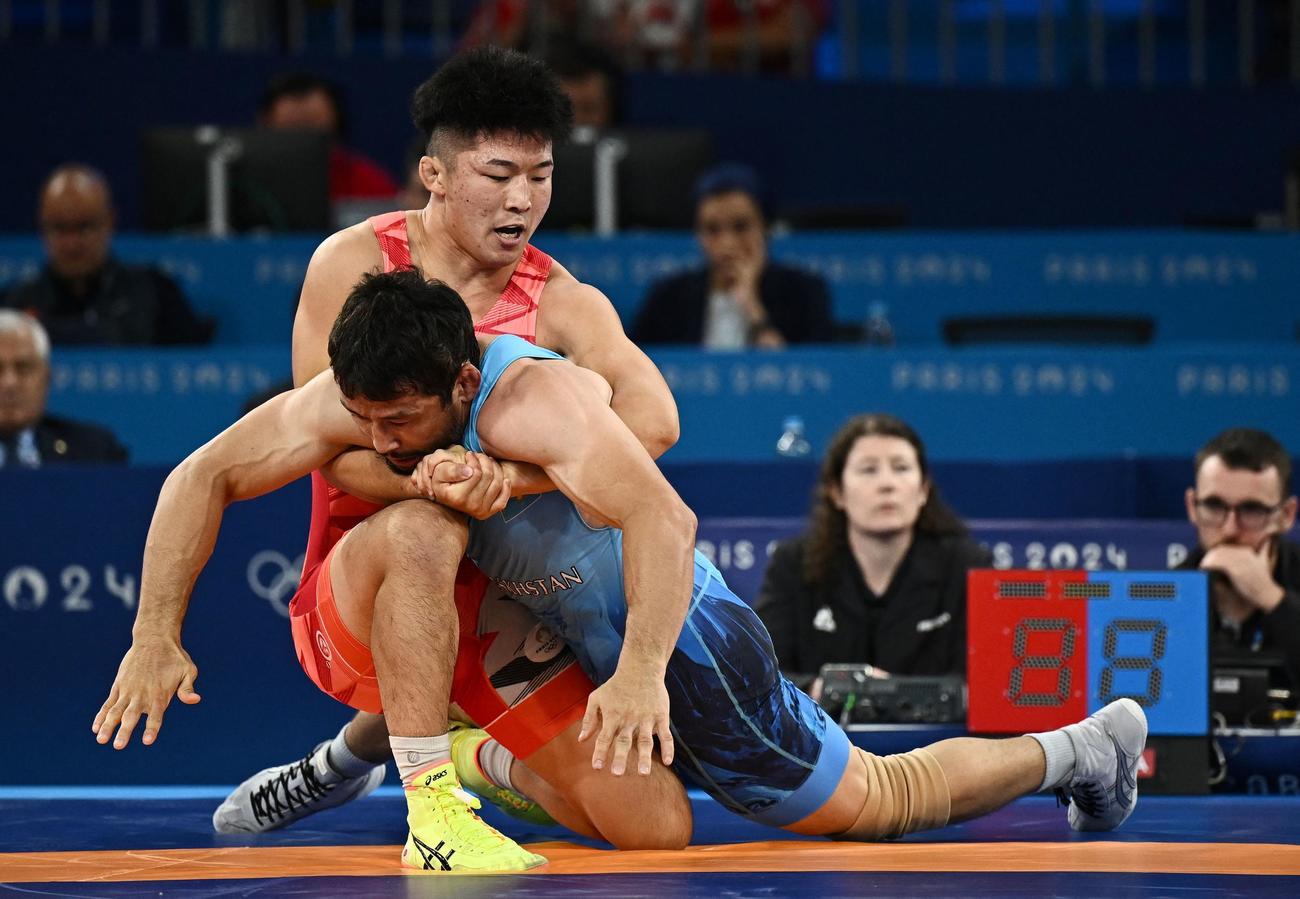 レスリング男子グレコローマンスタイル77キロ級決勝　カザフスタンのジャドラエフを攻める日本の日下（奥）（ロイター）