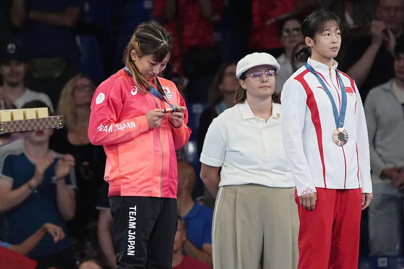 レスリング女子50キロ級の表彰式で須崎（左）は銅メダルを見つめる（撮影・パオロ　ヌッチ）