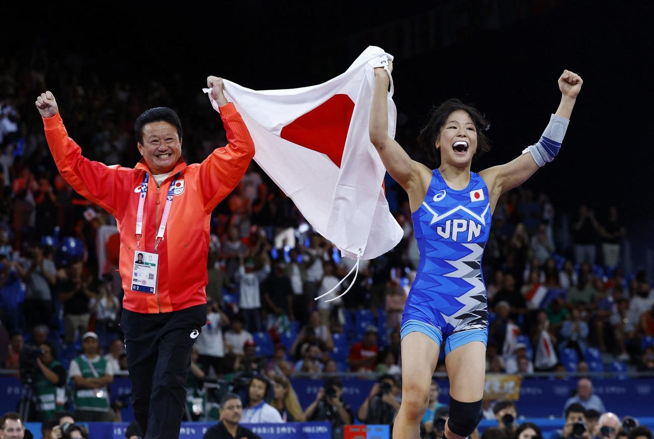 女子53キロ級決勝　金メダルに輝いた藤波朱理は、父の俊一コーチと一緒に日の丸を掲げる（ロイター）