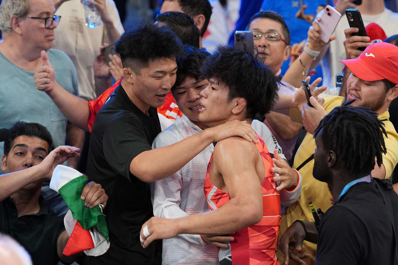 男子フリースタイル65キロ級決勝で金メダルを獲得した清岡（中央）は応援団の祝福を受ける（撮影・パオロ　ヌッチ）