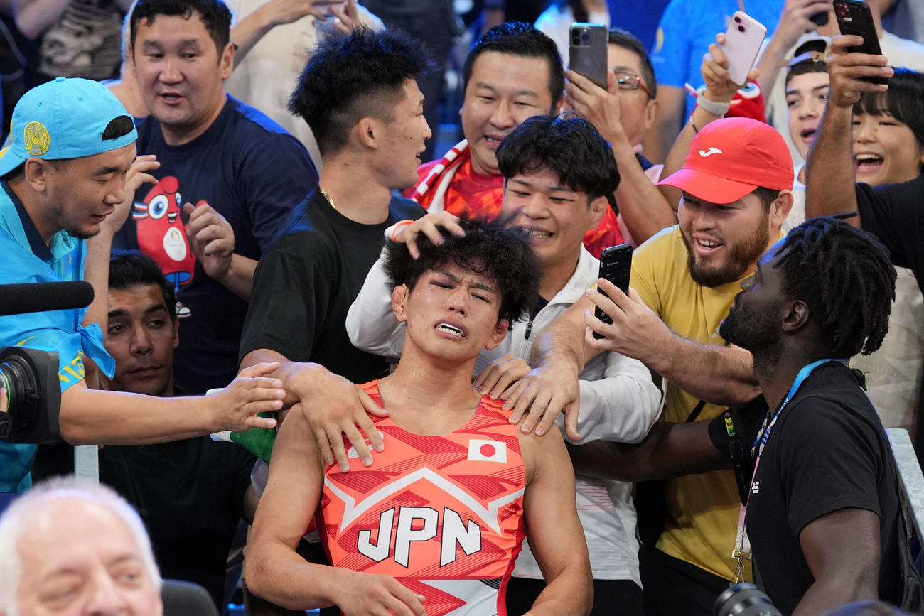 男子フリースタイル65キロ級決勝で金メダルを獲得した清岡（中央）は応援団の祝福を受ける（撮影・パオロ　ヌッチ）