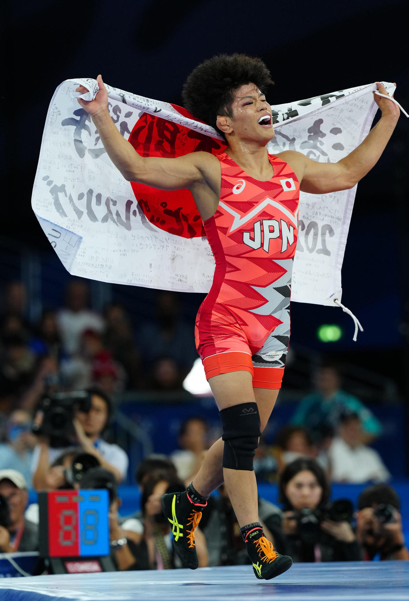 男子フリースタイル65キロ級決勝でアムーザドハリリを破り、優勝した清岡は日の丸を掲げる（撮影・江口和貴）