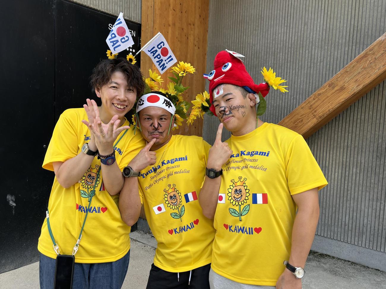 金メダルの鏡が好きなひまわりコーデで応援した、左から母ひとみさん、父師博さん、兄隼翔さん（撮影・松本航）