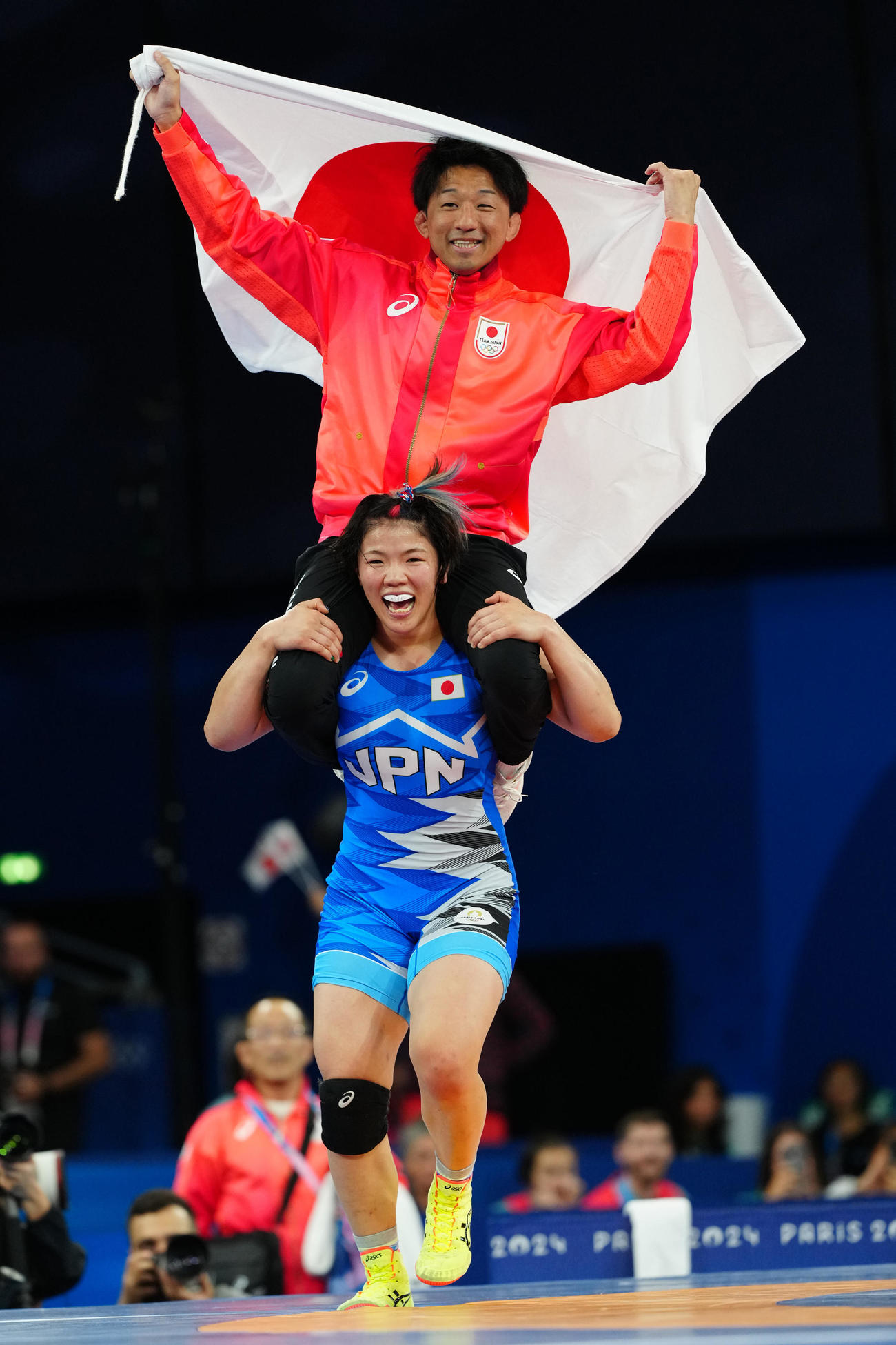 女子76キロ級決勝で優勝し前田コーチ（上）を肩車する鏡（撮影・江口和貴）