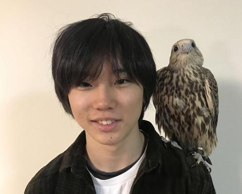 ペットのハヤブサを肩に乗せ、笑顔のスノーボード男子の国武