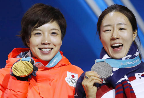 平昌冬季五輪スピードスケート女子５００メートルで獲得した金メダルを手に笑顔の小平奈緒（左）と銀メダルの韓国・李相花（共同）