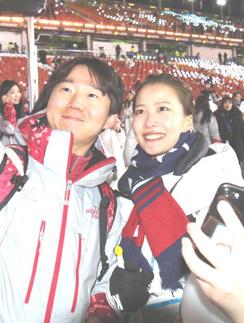 平昌五輪の閉会式でボランティアと記念撮影する、メガネを外したカーリング女子韓国代表スキップの金ウンジョン（右）（撮影・河野匠）