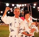 盆踊り会場から日本代表にエールを送る佐藤陸奥雄さん（左）、有子さん夫妻