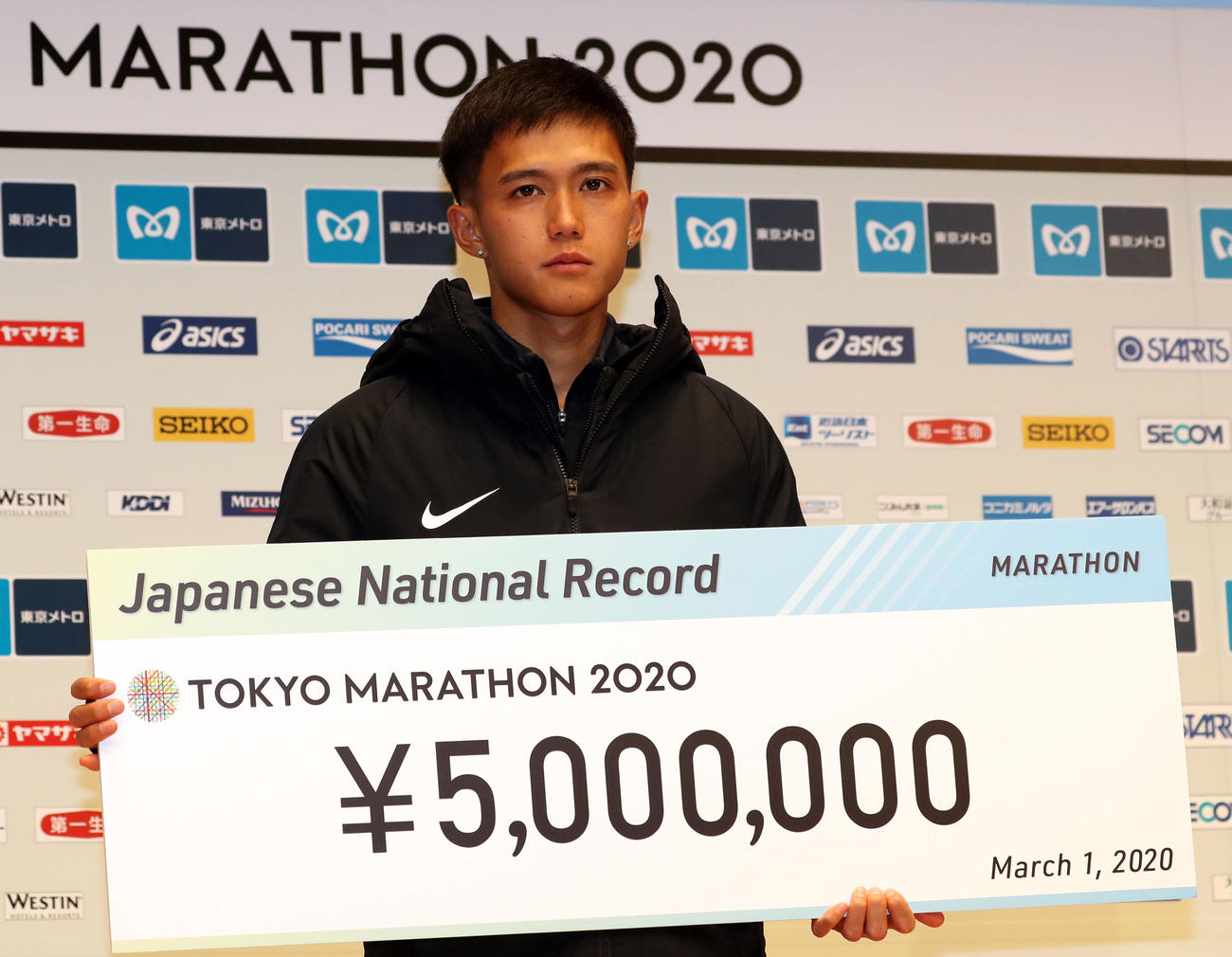 日本記録を更新し、500万円の報奨金のボードを手に記念撮影する大迫（撮影・狩俣裕三）