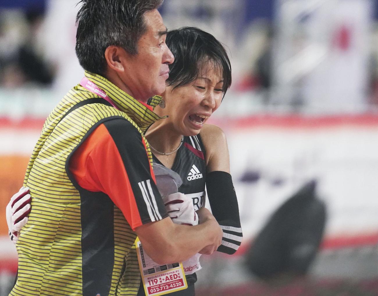 2位でゴールし、ワコールの永山忠幸監督（左）に支えられる安藤友香（共同）