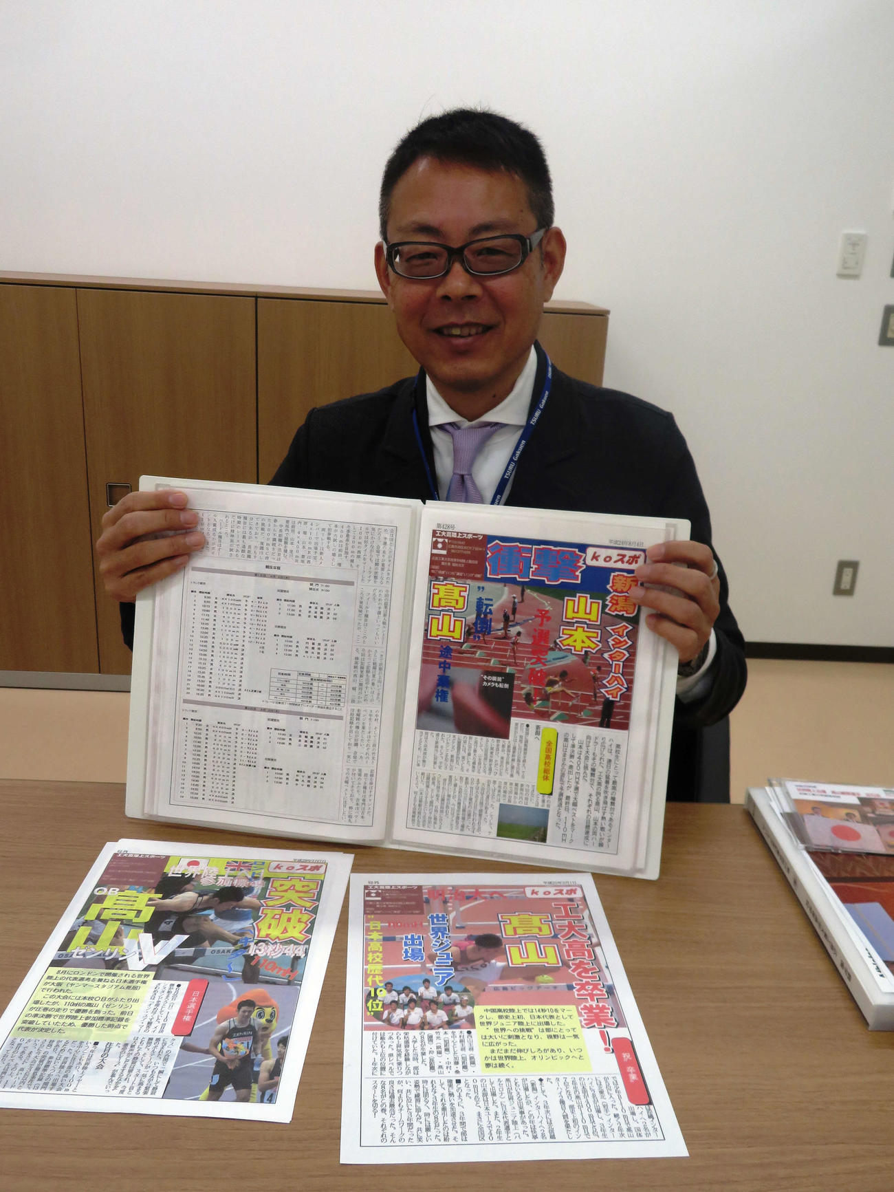 高山が掲載された「koスポ」を手にする福地光文教頭（撮影・上田悠太）