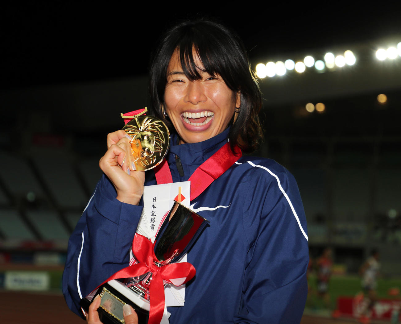 女子1万メートル　日本記録で1位となり表彰式で笑顔をみせる新谷仁美（2020年12月4日撮影）