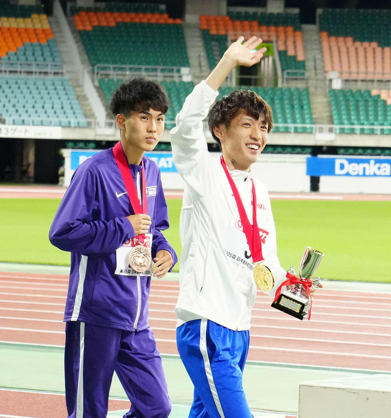 男子1万メートルで優勝した伊藤（右）は表彰式後、スタンドに手を振る。左は3位の鈴木（撮影・江口和貴）