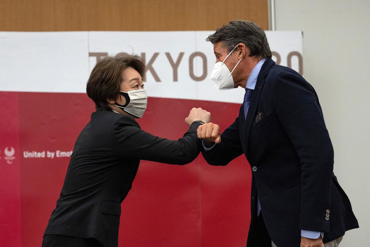 コー会長（右）と肘を合わせる橋本会長（ロイター）